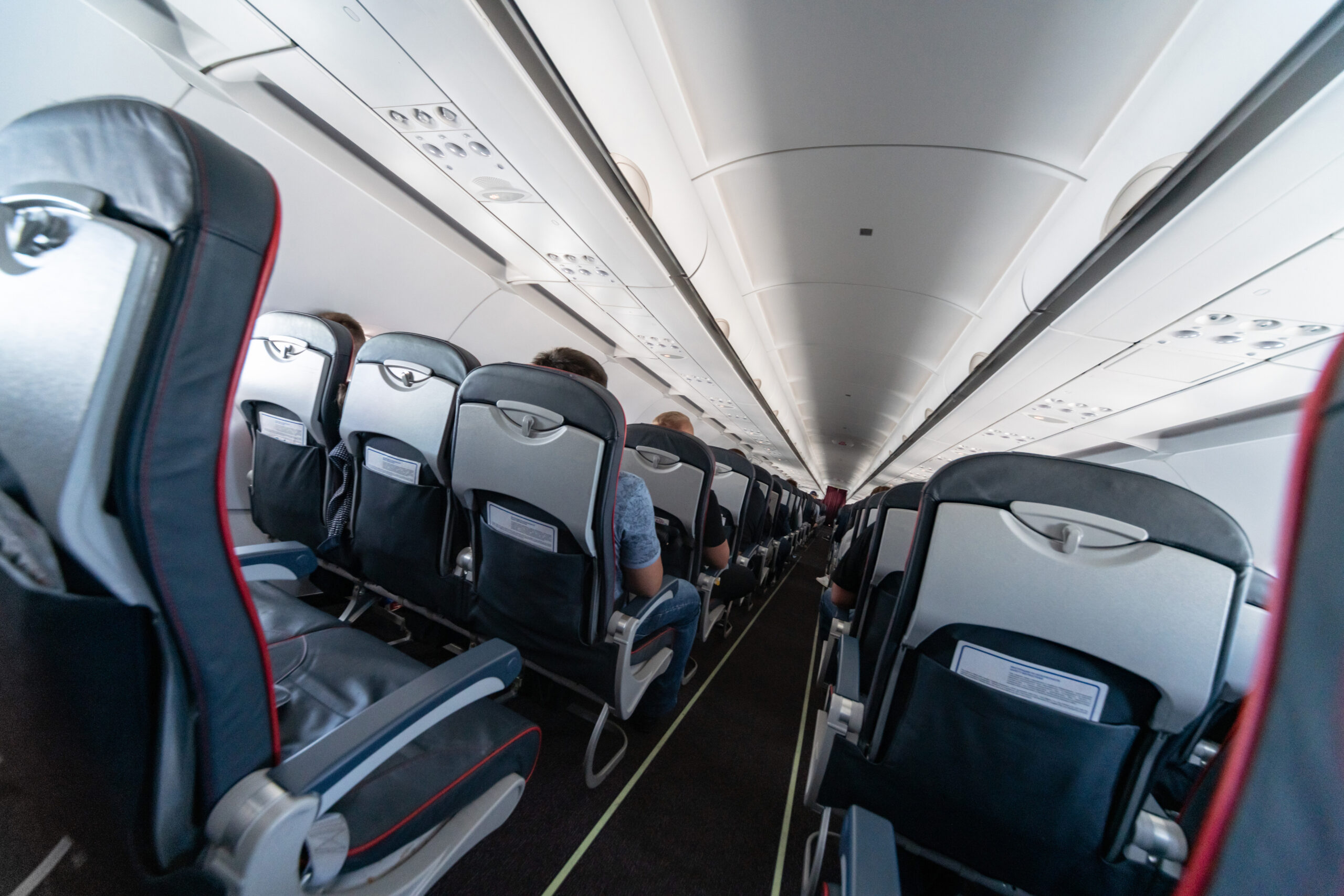 Cheap flights. Airplane cabin seats with passengers. Economy class of new cheapest low-cost airlines. Travel trip to another country. Turbulence in flight.